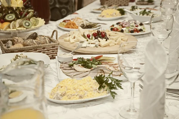 Saláták és ételek vannak, az ünnepi asztalra egy étteremben — Stock Fotó
