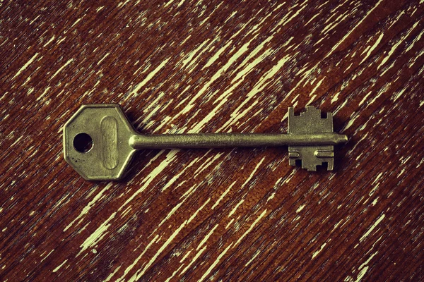 Door key on vintage wooden surface — Stock Photo, Image