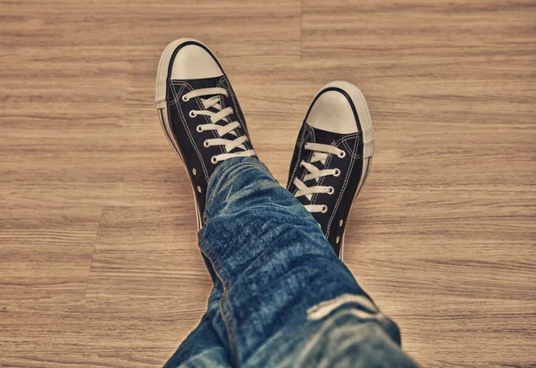 Legs in jeans and sneakers top view — Stock Photo, Image