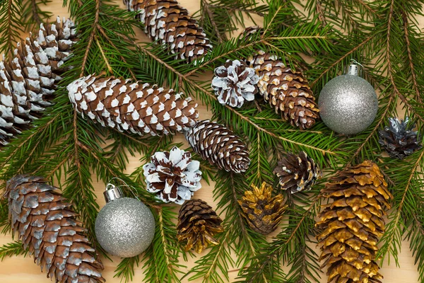 Hintergrund aus Tannenzweigen, Weihnachtsspielzeug und bunten Zapfen Stockbild