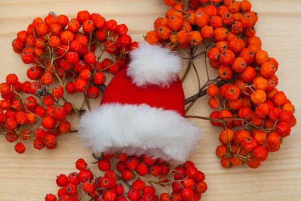 Decoraciones de Navidad - Santa Claus sombrero y bayas rojas de ceniza de montaña —  Fotos de Stock