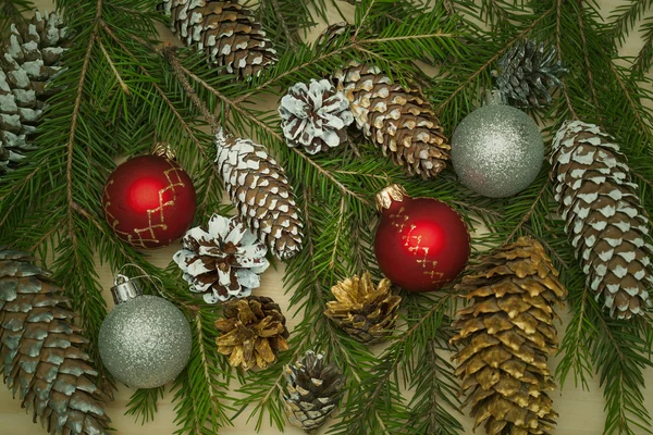 Fondo decorativo festivo de Año Nuevo. Rama de árbol de Navidad con pelotas de juguete de Navidad, conos de árbol de Navidad —  Fotos de Stock