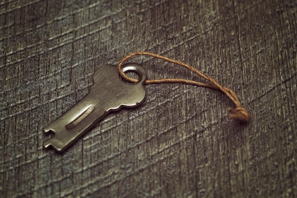 Винтажный ключ на деревянном текстурированном фоне — стоковое фото