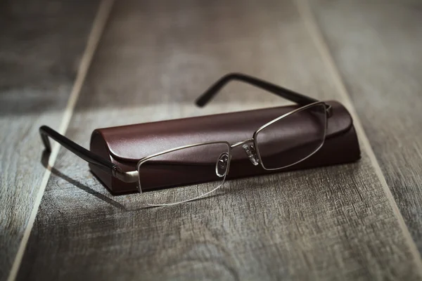 Elegantní brýle podnikatel s víkem, na dřevěné pozadí — Stock fotografie