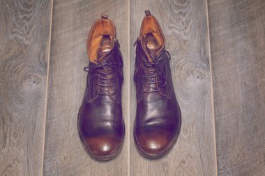 Ahşap zemin üzerinde kahverengi deri ayakkabı