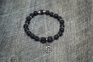 Dekoratif taşlar ve bir at nalı şeklinde bir kolye kolundaki bilezik