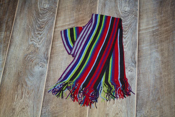 Colorful winter scarf on a wooden surface — Stock Photo, Image