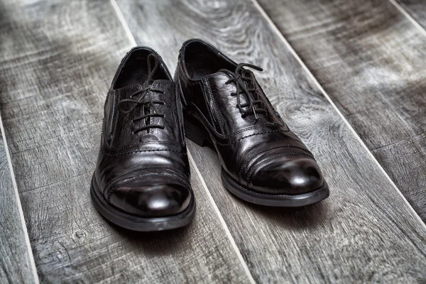 Pessoas, negócio, moda e calçado conceito. Sapatos pretos clássicos em um fundo de madeira — Fotografia de Stock