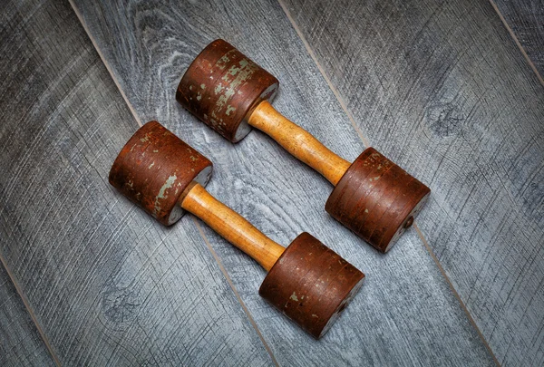 Mancuerna vintage oxidada en el gimnasio en el suelo de madera — Foto de Stock