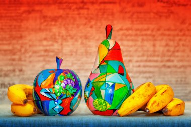 El ile organik muz boyalı ahşap elma ve armut. Sanatçı tarafından süslenmiş dekoratif ahşap meyve