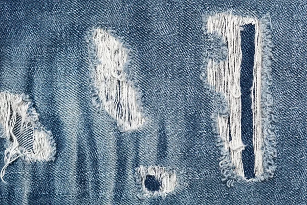 Textura de fundo de denim com um especialmente criado buracos envelhecidos — Fotografia de Stock