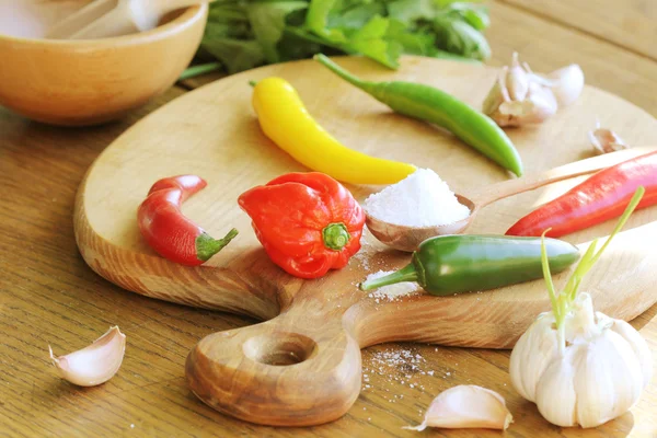 Andere variëteit van hete pepers en specerijen op de snijplank — Stockfoto