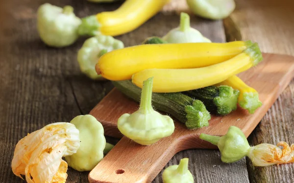 Verse biologische patisson en courgette op de houten tafel — Stockfoto