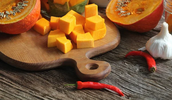 Zucca tritata su tagliere rustico e ingredienti per una gustosa cucina vegetariana, in stile scuro — Foto Stock