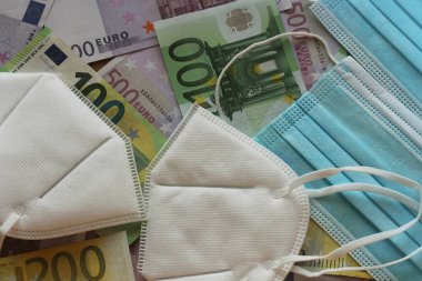 Tıbbi maske ve para. Cerrahi maske. COVID-19 yüz maskesi sıkıntısına neden oldu. Euro banknotları ve tıbbi yüz maskeleri.