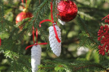 Yeşil arka planda Noel süslemesi. Noel topları ve süslemelerle köknar dalında çam kozalakları