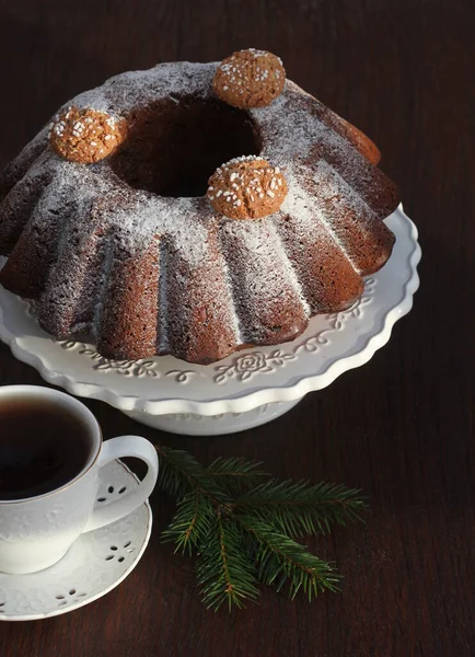 Chocolate bundt cake with icing sugar and coffee cup. Christmas background — Stock Photo, Image