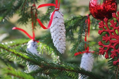 Yeşil arka planda Noel süslemesi. Noel topları ve süslemelerle köknar dalında çam kozalakları .