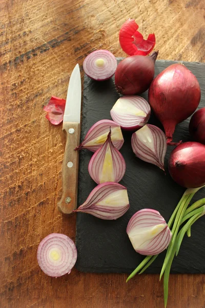 Cebollas rojas en la tabla de cortar —  Fotos de Stock