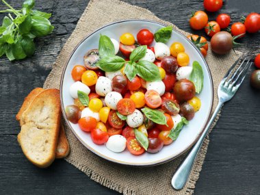 Mozzarella, domates, fesleğen ve zeytinyağlı antipasti salatası. 