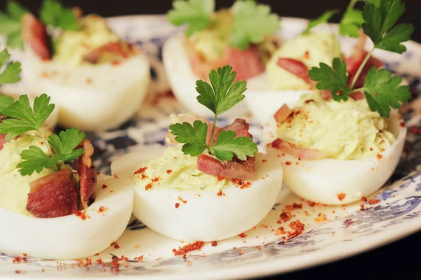 Deviled eggs appetizer with avocado and bacon — Stock Photo, Image