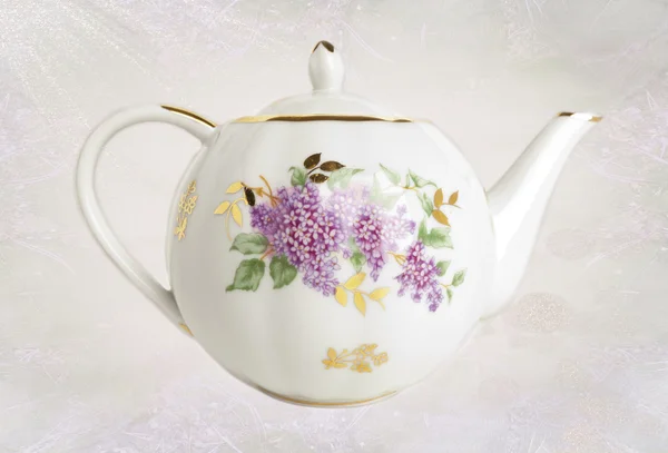 Porcelain teapot with floral ornament over original background — Stock Photo, Image