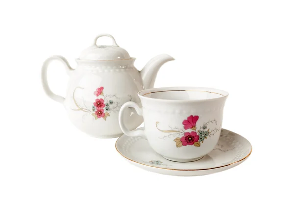 Tetera de porcelana, taza de té y platillo con patrones florales aislados sobre blanco — Foto de Stock