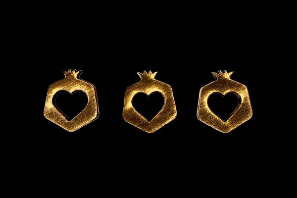 Drei Herzen in hölzernem Granatapfel isoliert auf schwarzem Hintergrund — Stockfoto