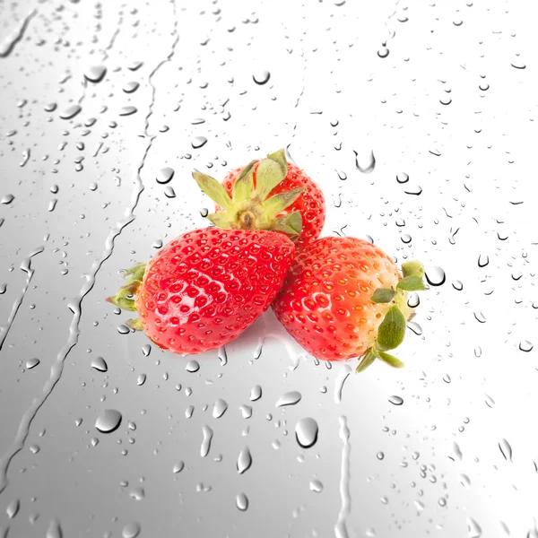 Fraises juteuses fraîches sur des surfaces humides ou fond de gouttes d'eau — Photo