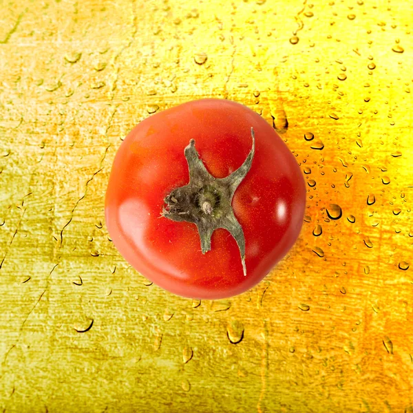 Röd tomat på gult vatten droppar bakgrund — Stockfoto