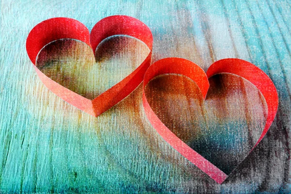 Två röda papper hjärtan på trä bakgrund i grunge stil — Stockfoto
