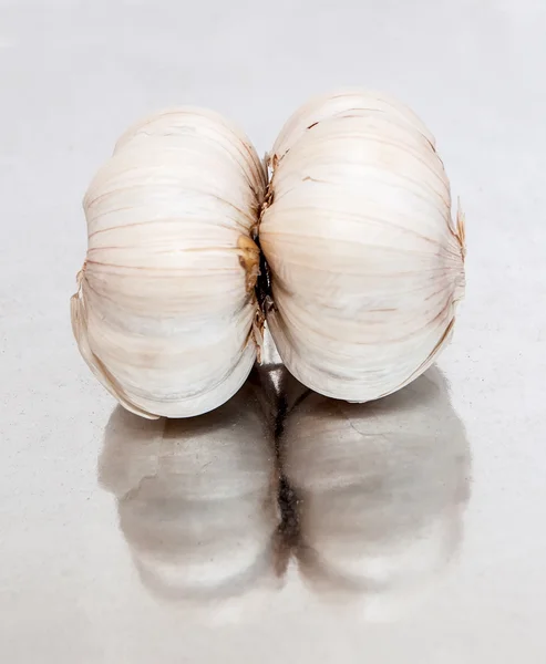 Garlic lying on the mirror surface — Stock Photo, Image