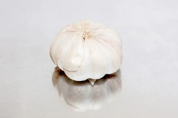 Garlic lying on the mirror surface — Stock Photo, Image