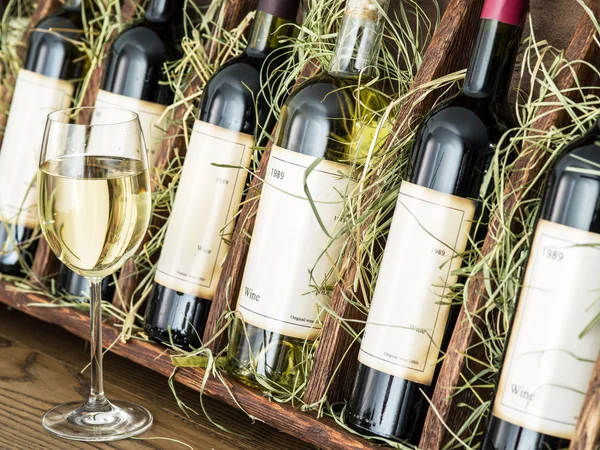 Glasflaskor för vin på en trähylla. — Stockfoto