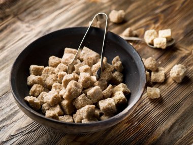 Ahşap masa üzerinde kapta şeker kamışı küp.