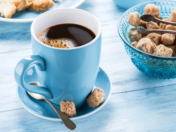 Tasse Kaffee, Milchkanne, Zuckerrohrwürfel und Obstkuchen. — Stockfoto