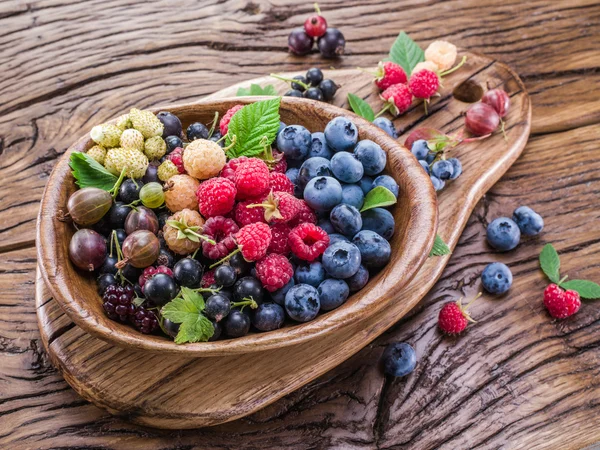 Ripe berries in the wooden bowl. — Stock Photo, Image