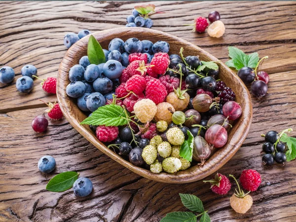 Ripe berries in the wooden bowl. — Stock Photo, Image