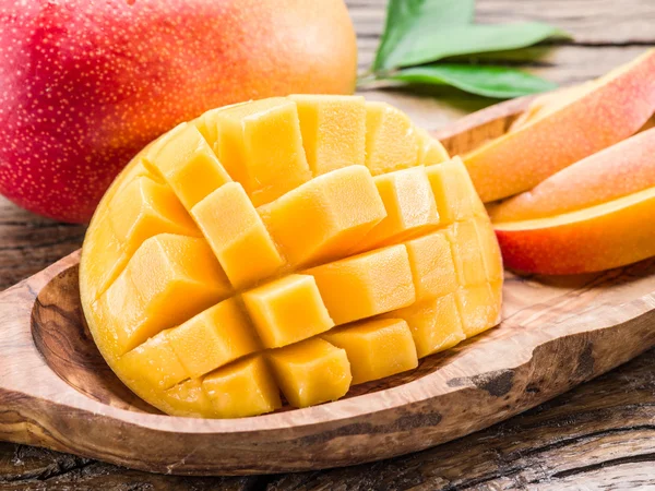 Mango frukt och mango kuber på trä bordet. — Stockfoto
