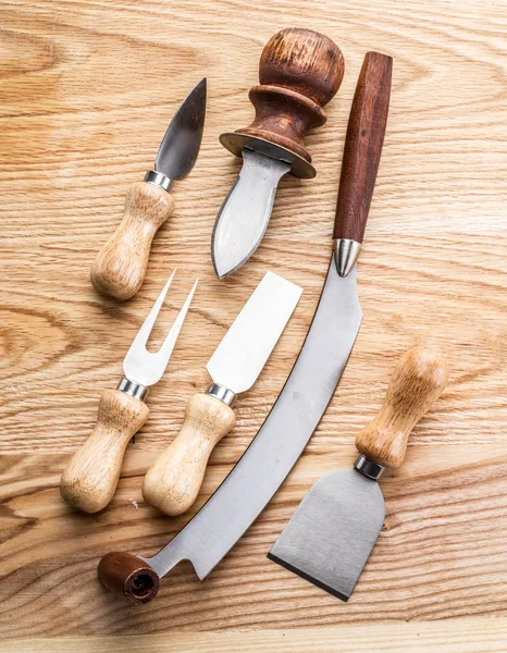 Сирні ножі на дерев'яному фоні . — стокове фото