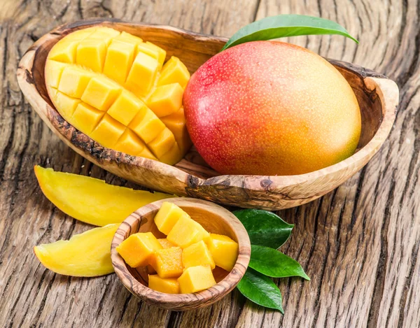 Cubos de mango y fruta de mango en la mesa de madera . — Foto de Stock