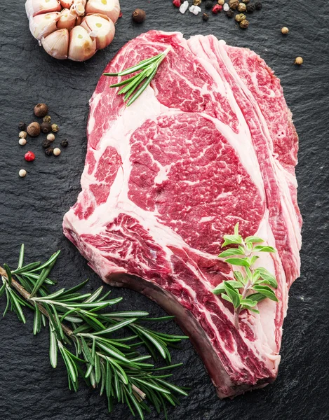 Rib eye steak with spices on the black background. — Stock Photo, Image