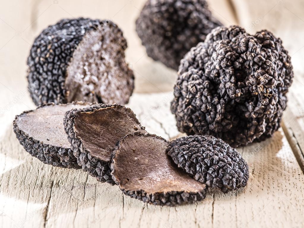 Black truffles on the old wooden table.