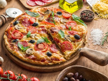 Mantar, salam ve domates pizza.