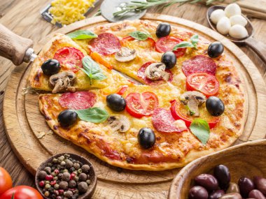 Mantar, salam ve domates pizza.