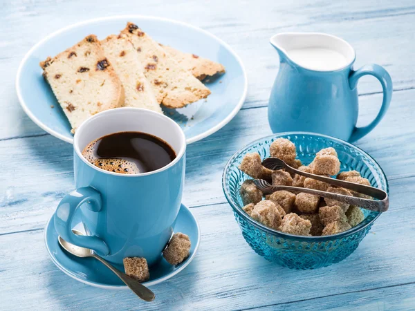 Tasse Kaffee, Milchkanne, Zuckerrohrwürfel und Obstkuchen. — Stockfoto