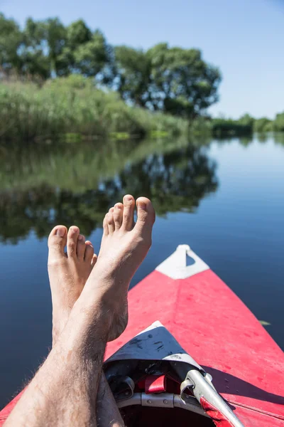 Man's legs over canoe. Resting time. — Stock Photo, Image