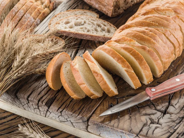 Skivad vitt bröd på plankan. — Stockfoto