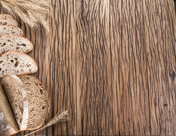 Sliced black bread on the wooden plank. — Stock Photo, Image