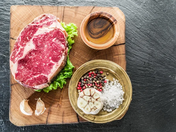 Biefstuk Ribeye met specerijen op de oude houten lade. — Stockfoto